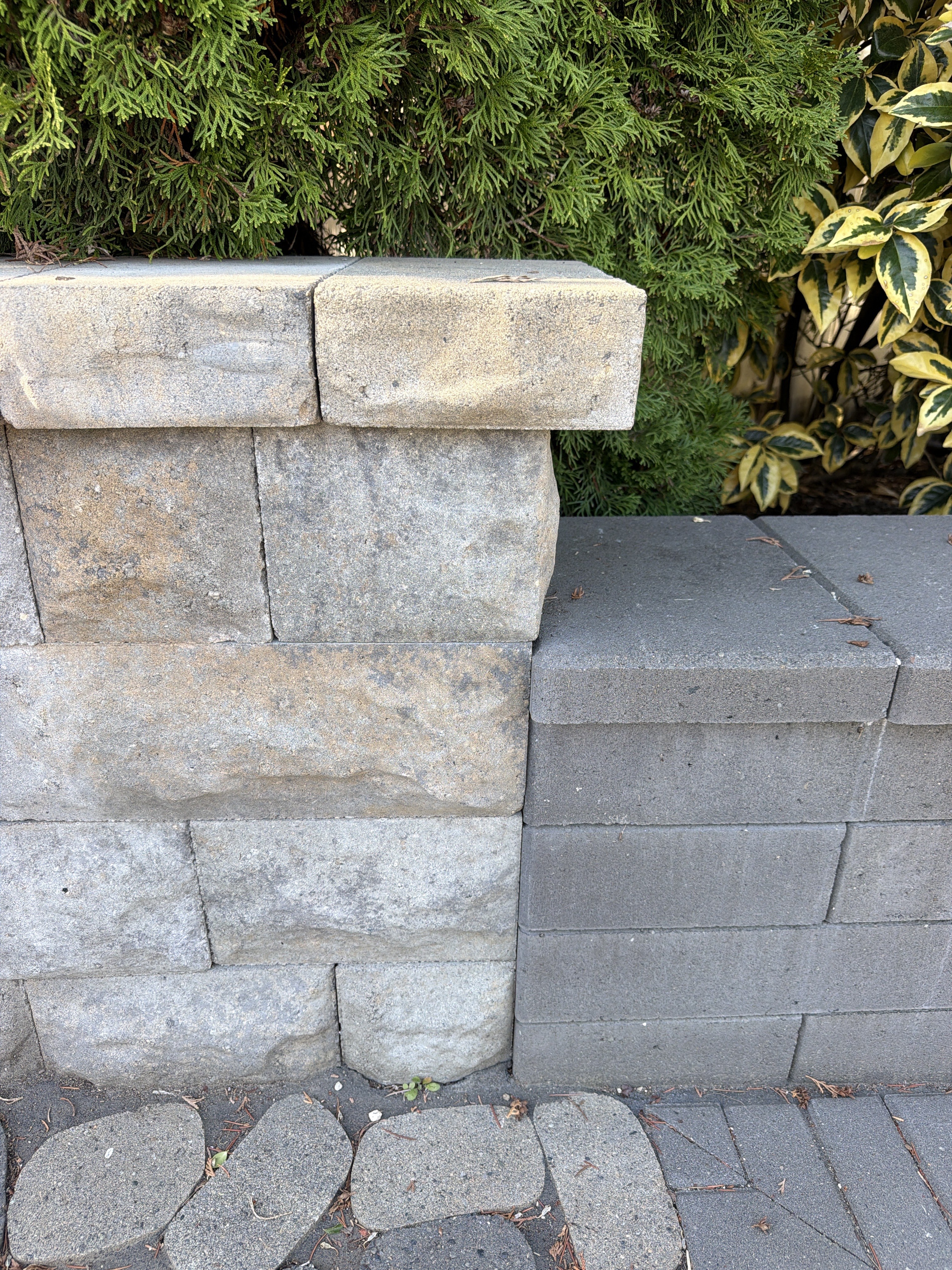 Two adjoining capped wall sections with different textures and heights.